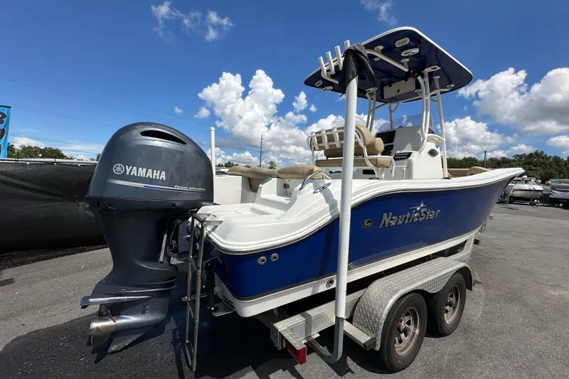 Slide: The Image of 2020 NauticStar 2302 Legacy boat with Yamaha engine on trailer under blue sky. - 3