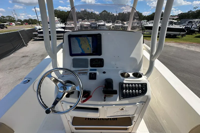 Slide: The Image of 2020 NauticStar 2302 Legacy boat dashboard with steering wheel and navigation display. - 30