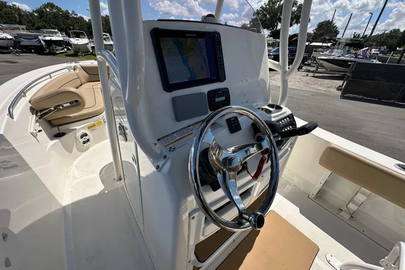 Slide: The Image of 2020 NauticStar 2302 Legacy boat cockpit with steering wheel and navigation display. - 32