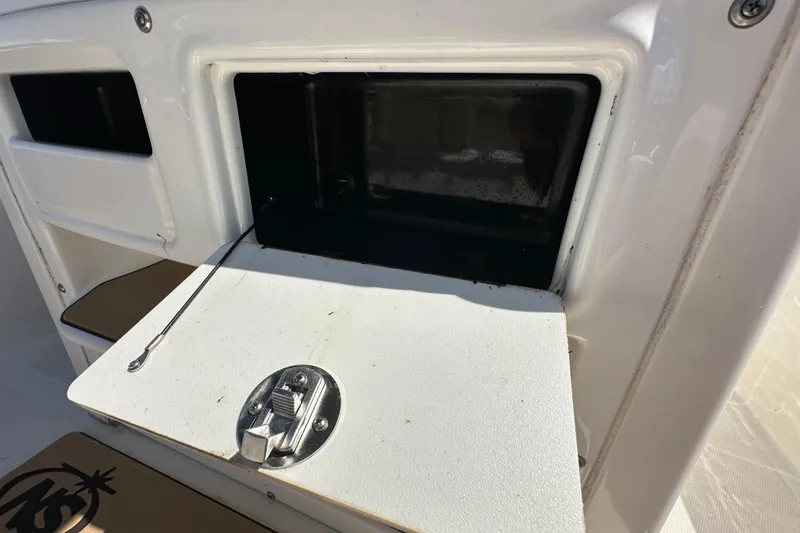 Slide: The Image of 2020 NauticStar 2302 Legacy boat storage compartment with open hatch and latch. - 38