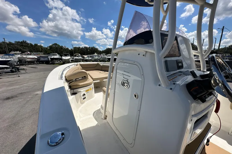 Slide: The Image of 2020 NauticStar 2302 Legacy boat interior with seating and console, under a sunny sky. - 41