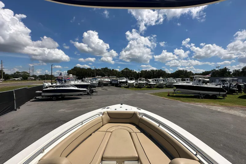 Slide: The Image of 2020 NauticStar 2302 Legacy boat in a sunny outdoor showroom with other boats. - 46