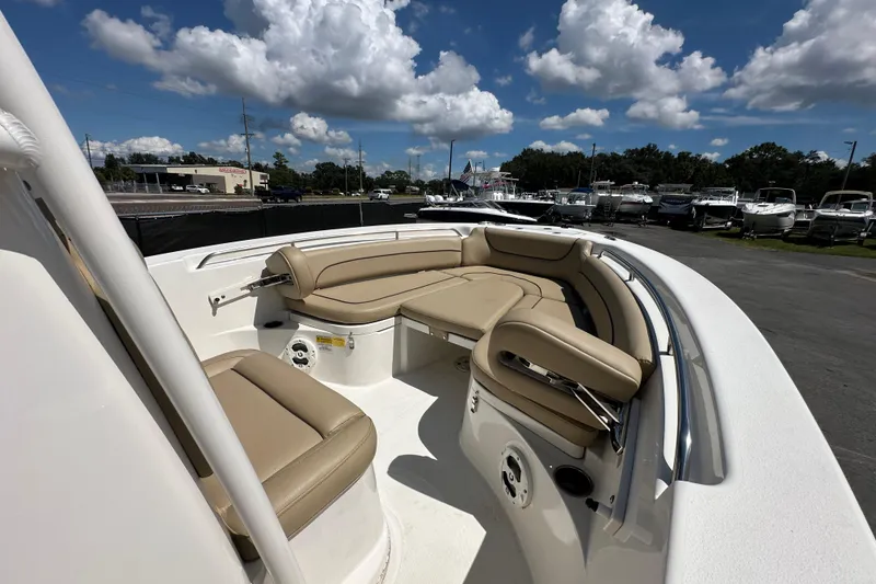 Slide: The Image of 2020 NauticStar 2302 Legacy boat with tan seating under a blue sky with clouds. - 49