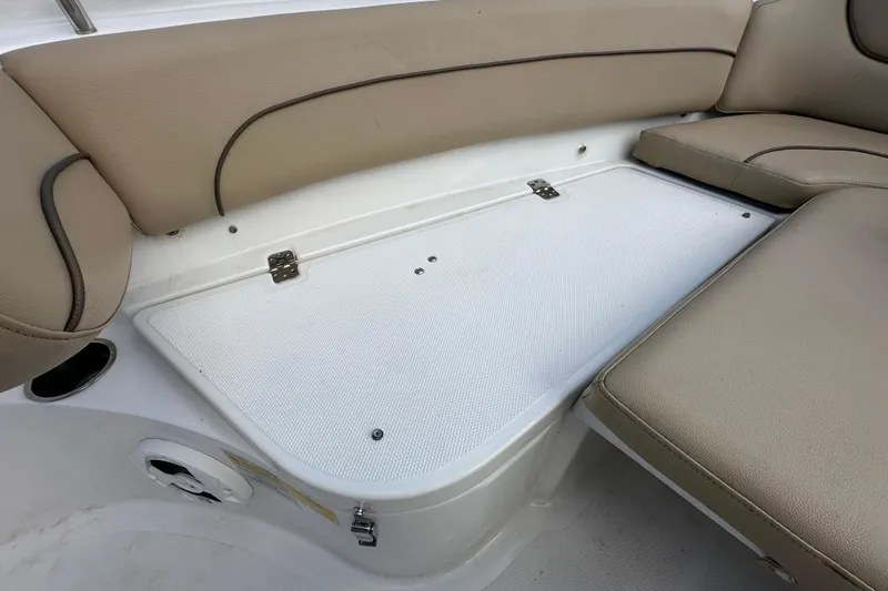 Slide: The Image of 2020 NauticStar 2302 Legacy boat seating with storage compartment and beige cushions. - 54