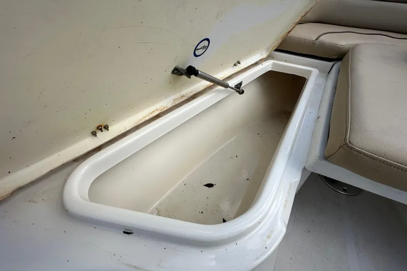 Slide: The Image of Open storage compartment on 2020 NauticStar 2302 Legacy boat, with beige seating. - 55