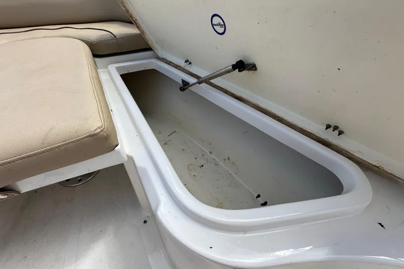 Slide: The Image of Open storage compartment on 2020 NauticStar 2302 Legacy boat with beige seating. - 58
