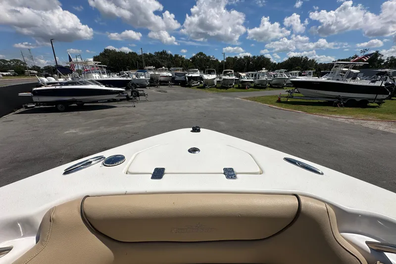 Slide: The Image of 2020 NauticStar 2302 Legacy boat in a marina with other boats under a blue sky. - 59