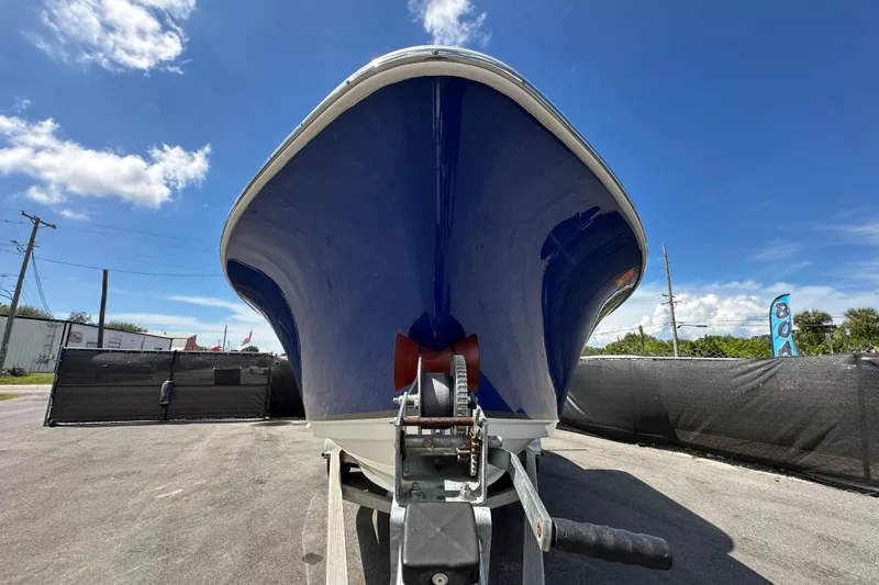 Slide: The Image of 2020 NauticStar 2302 Legacy boat with 200 horsepower engine, parked under a blue sky. - 6
