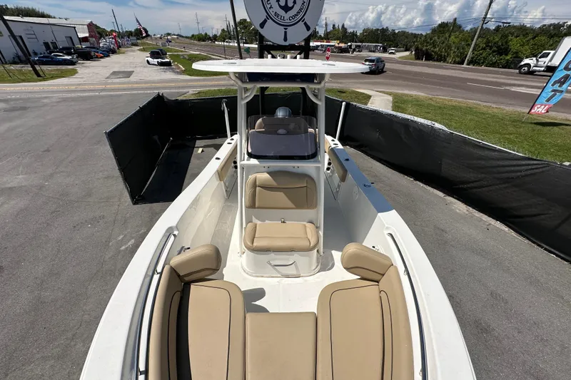 Slide: The Image of 2020 NauticStar 2302 Legacy boat with beige seating, parked on a paved lot. - 63