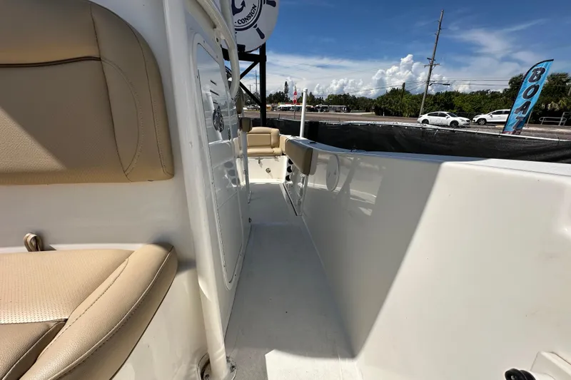 Slide: The Image of 2020 NauticStar 2302 Legacy boat interior with beige seating and clear sky. - 73