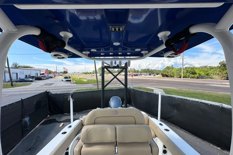 Slide: The Image of 2020 NauticStar 2302 Legacy boat interior with blue canopy and beige seating. - 74