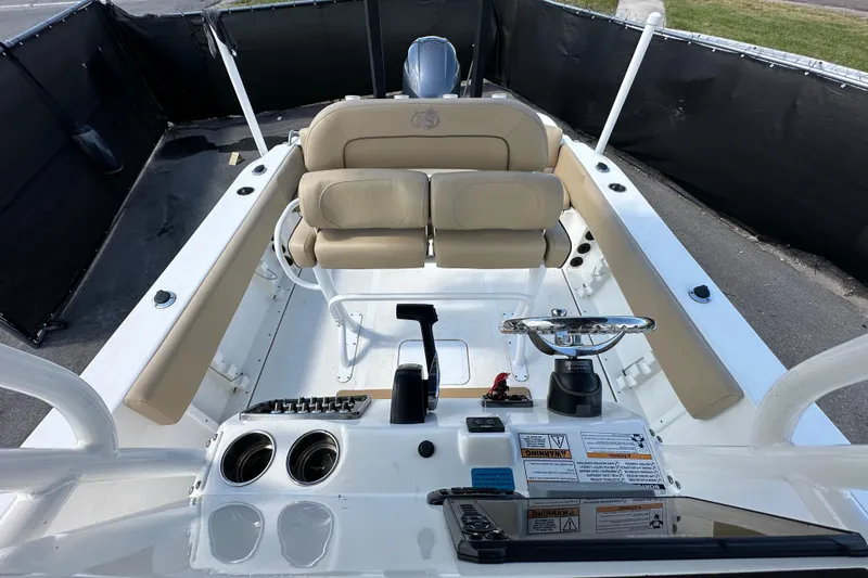 Slide: The Image of 2020 NauticStar 2302 Legacy boat interior with beige seating and control panel. - 75