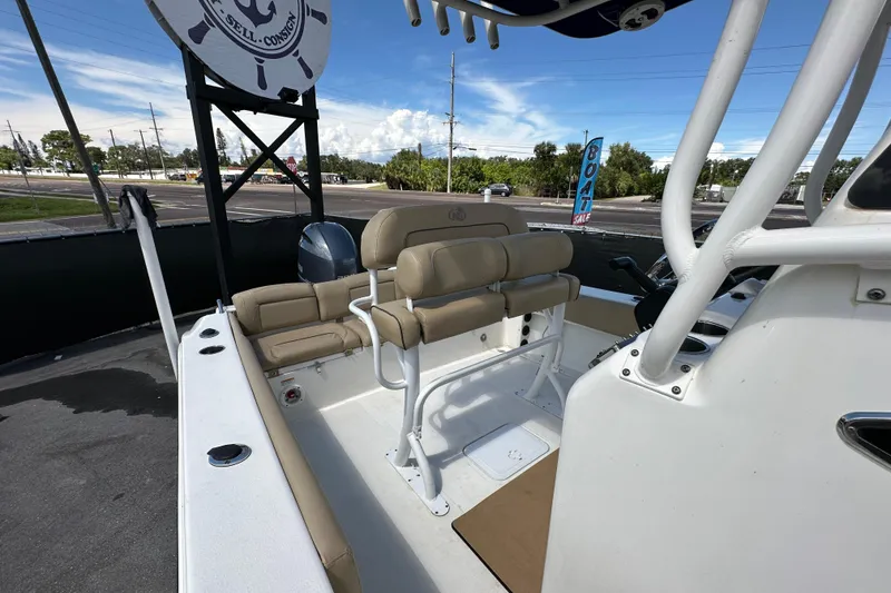 Slide: The Image of 2020 NauticStar 2302 Legacy boat interior with beige seating and console. - 76