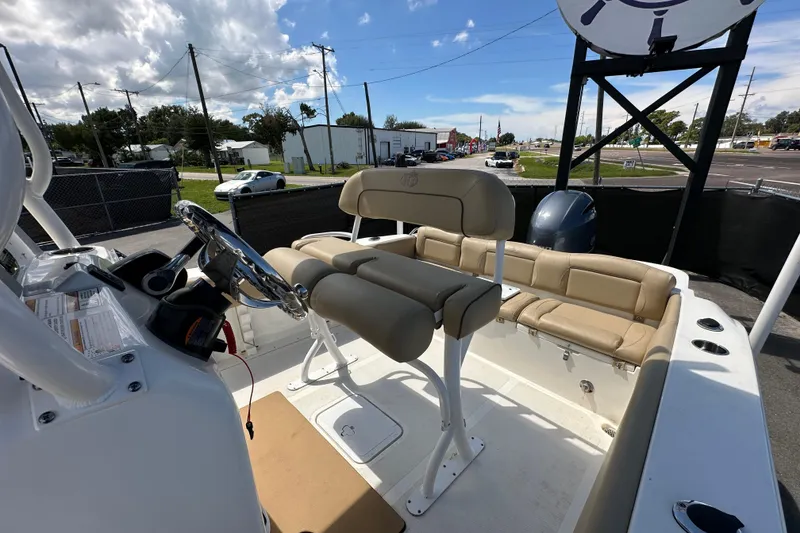 Slide: The Image of 2020 NauticStar 2302 Legacy boat interior with beige seating and steering console. - 77