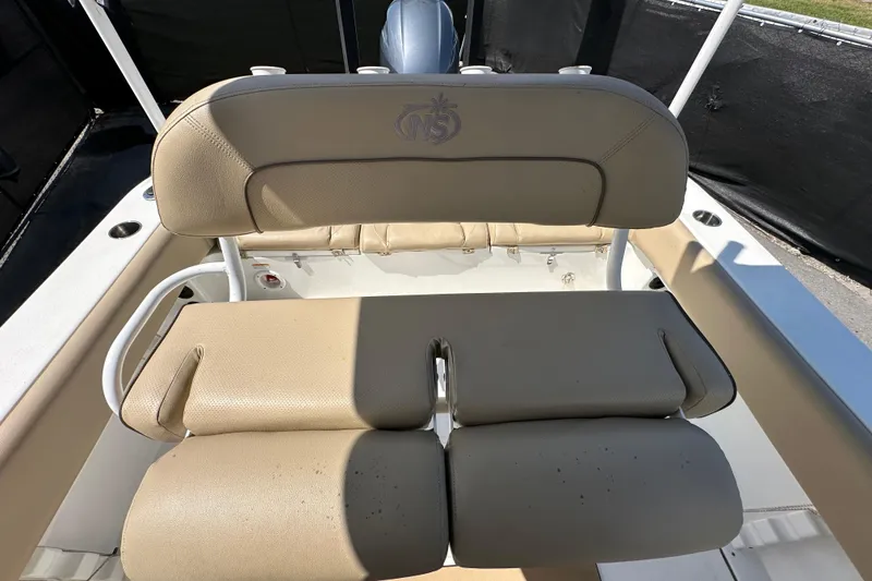 Slide: The Image of 2020 NauticStar 2302 Legacy boat seat with beige upholstery and logo detail. - 79