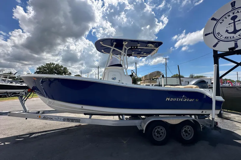 Slide: The Image of 2020 NauticStar 2302 Legacy with Yamaha four-stroke outboard motor under cloudy sky. - 8