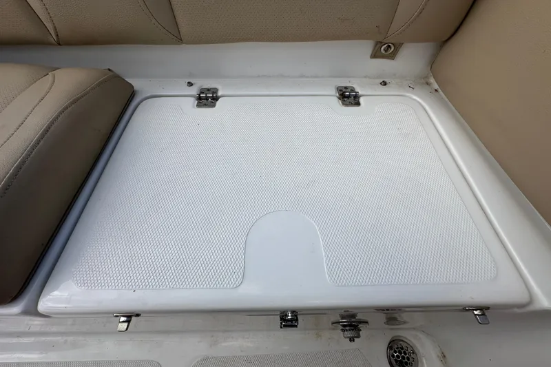 Slide: The Image of 2020 NauticStar 2302 Legacy boat storage compartment with beige seating. - 90