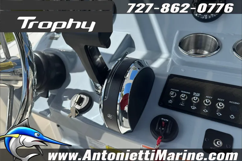 Slide: The Image of 2026 Trophy T20CC Center Console boat controls with steering wheel and switches. - 12