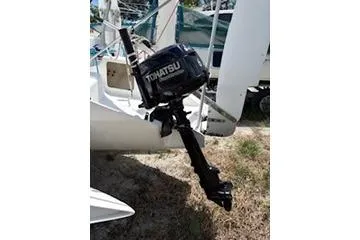 Slide: The Image of Outboard motor on a 2003 Corsair F-24MKII sailboat, parked on grass. - 5