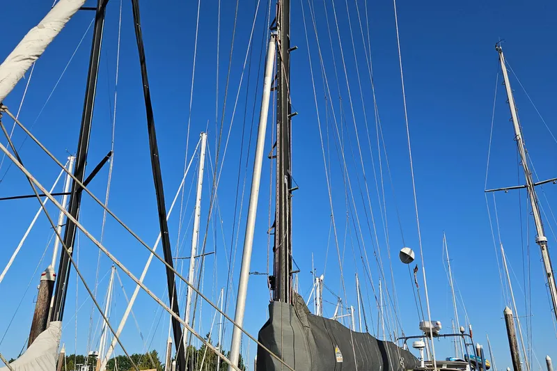 Slide: The Image of Masts and rigging of a 1979 Fast Passage 39 sailboat against a clear blue sky. - 10