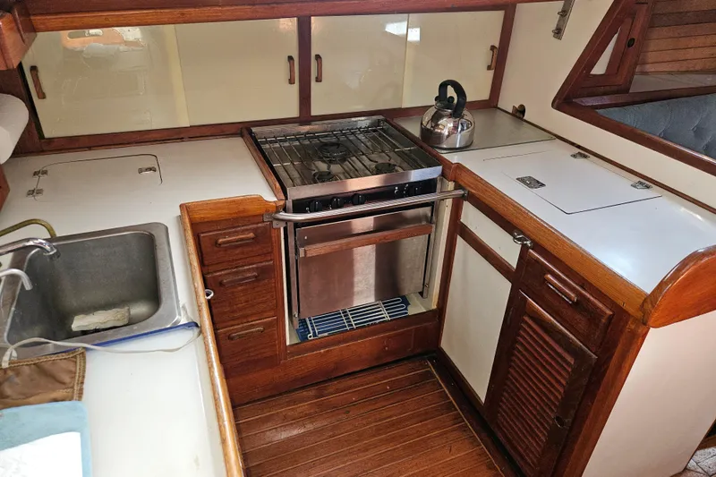 Slide: The Image of 1979 Fast Passage 39 yacht kitchen with stove, sink, and wooden cabinetry. - 21