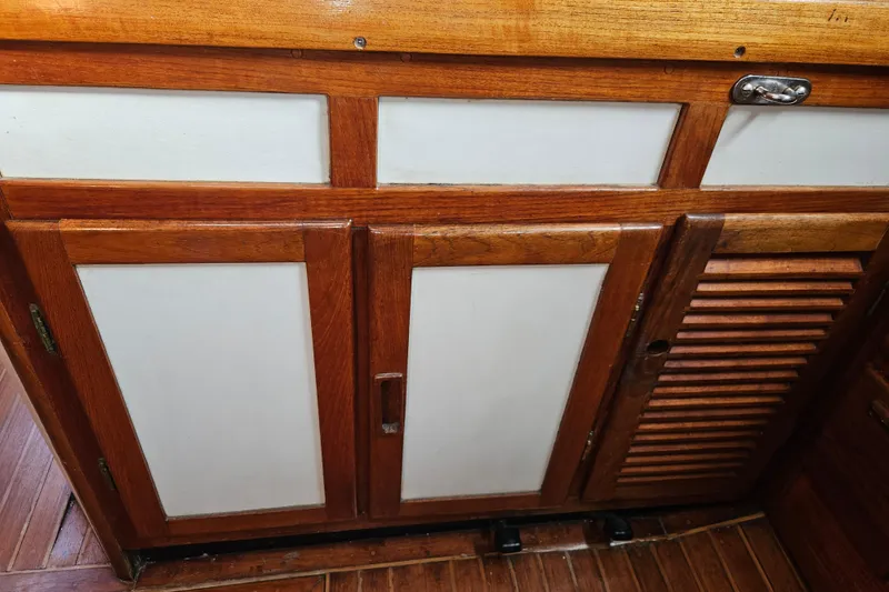 Slide: The Image of Wooden cabinetry on a 1979 Fast Passage 39 sailboat, featuring white panels and louvered door. - 27