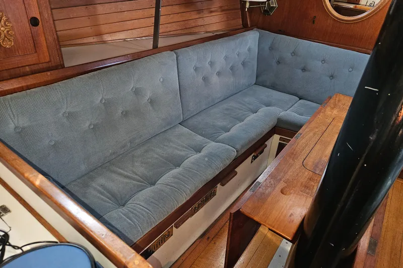 Slide: The Image of Interior of 1979 Fast Passage 39 sailboat with blue cushioned seating and wooden accents. - 29