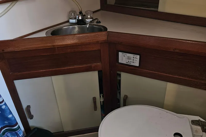 Slide: The Image of 1979 Fast Passage 39 yacht bathroom with sink, wooden cabinetry, and toilet. - 31