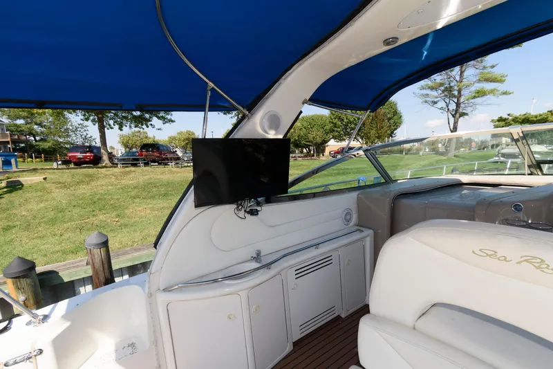 Slide: The Image of Sea Ray 380 Sundancer 2000 interior with TV, blue canopy, and white seating. - 8