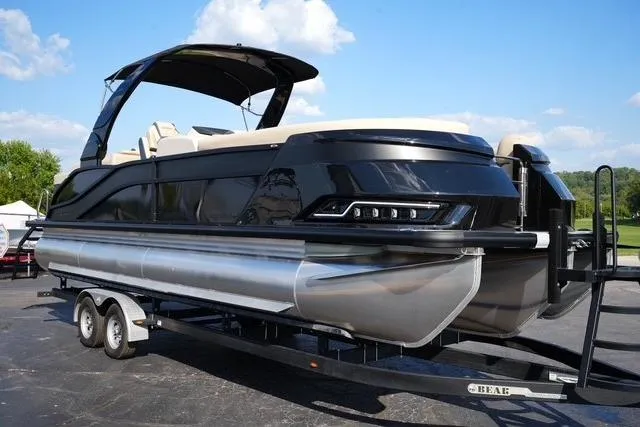 The Image of 2026 Harris Grand Mariner 250 pontoon boat on trailer, sleek black design, sunny day. - 0