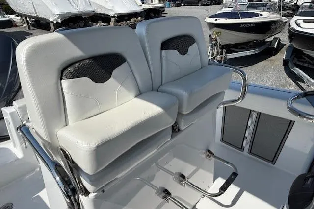Slide: The Image of 2025 Wellcraft 243 Fisherman boat seats, white leather, dual seating, outdoor marina setting. - 10