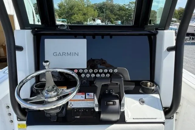Slide: The Image of 2025 Wellcraft 243 Fisherman boat dashboard with Garmin navigation system and steering wheel. - 6
