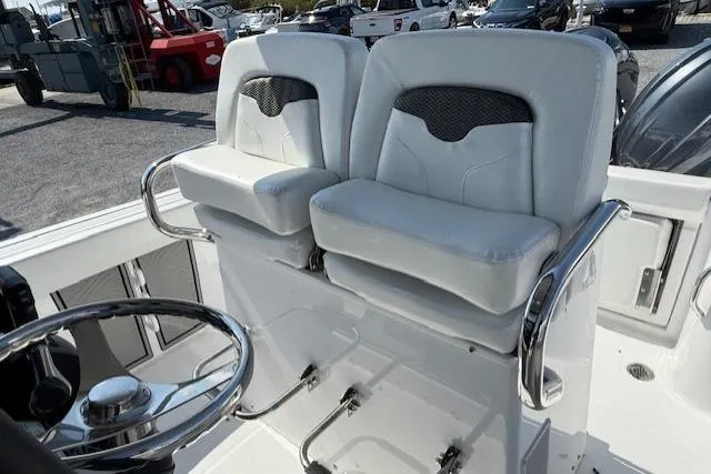 Slide: The Image of 2025 Wellcraft 243 Fisherman boat with dual white cushioned seats and steering wheel. - 9