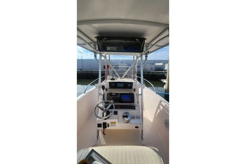 Slide: The Image of 1999 Grady-White Advance 247 boat cockpit with steering wheel and navigation equipment. - 13