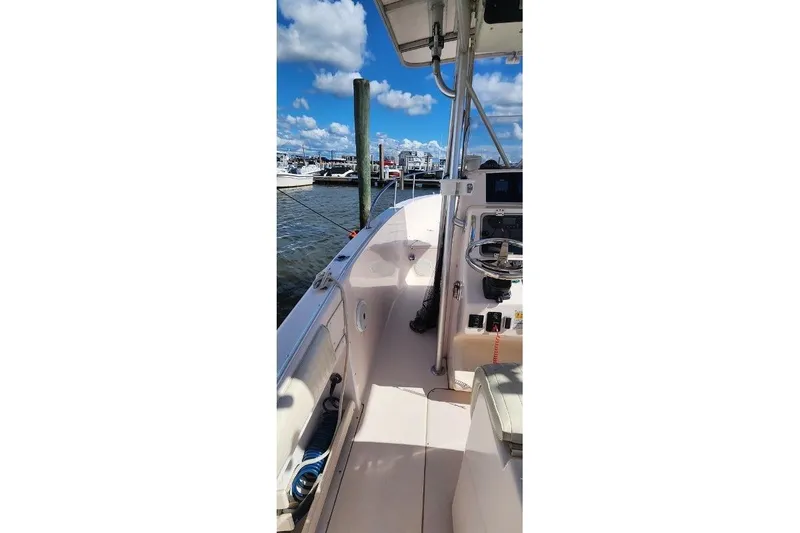Slide: The Image of 1999 Grady-White Advance 247 boat docked at marina under blue sky. - 14