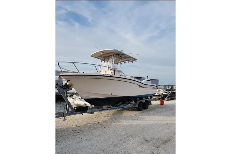 Slide: The Image of 1999 Grady-White Advance 247 boat on trailer, parked outdoors under cloudy sky. - 24