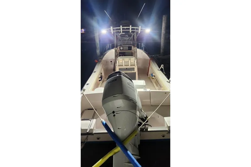 Slide: The Image of 1999 Grady-White Advance 247 boat with illuminated deck and powerful outboard motor. - 8