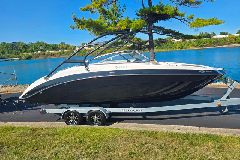 Slide: The Image of 2013 Yamaha Boats 242 Limited S on trailer by a scenic lake. - 10
