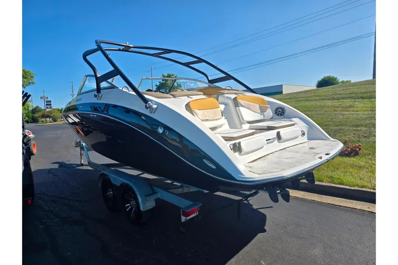 Slide: The Image of 2013 Yamaha Boats 242 Limited S on trailer, sleek design, sunny day. - 3