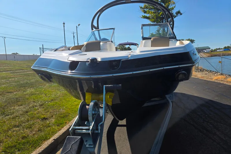 Slide: The Image of 2013 Yamaha Boats 242 Limited S on trailer, parked near water. - 6