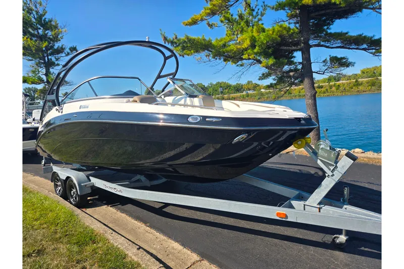 Slide: The Image of 2013 Yamaha Boats 242 Limited S on trailer by a lake, surrounded by trees. - 9