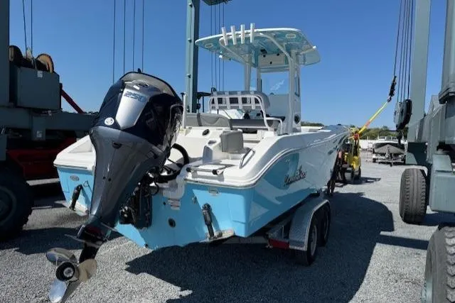 Slide: The Image of 2023 NauticStar 242L Offshore boat on trailer, featuring outboard motor, in a marina setting. - 4