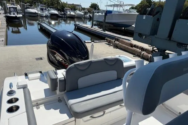 Slide: The Image of 2023 NauticStar 242L Offshore boat docked at marina with outboard motor. - 7