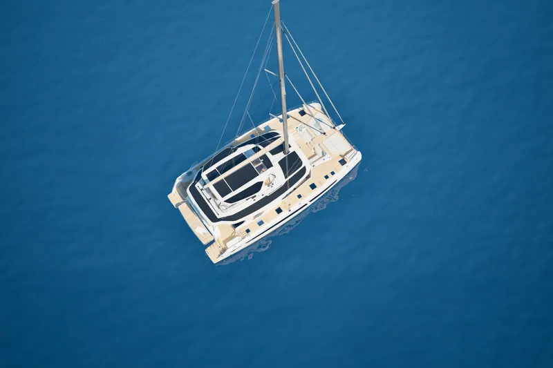 Slide: The Image of Aerial view of 2026 Fountaine Pajot 55 catamaran sailing on calm blue waters. - 13