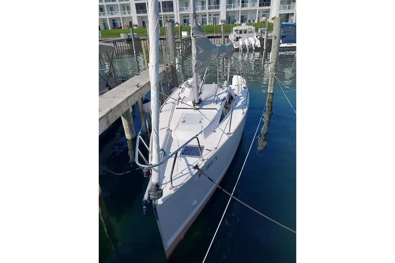 Slide: The Image of 2014 Catalina 275 Sport sailboat docked in a marina, surrounded by clear water. - 2