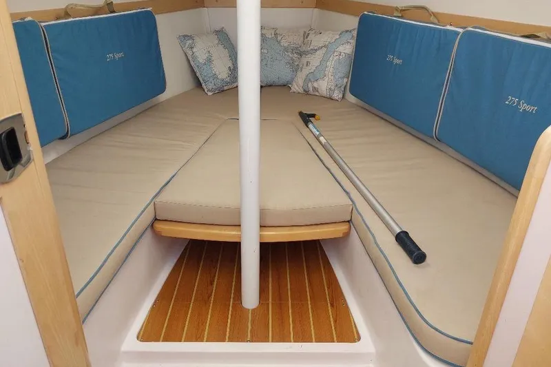 Slide: The Image of Interior of 2014 Catalina 275 Sport sailboat with cushioned seating and wooden flooring. - 7