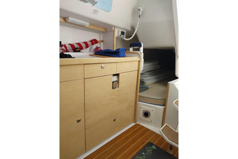 Slide: The Image of 2014 Catalina 275 Sport cabin interior with wooden cabinetry and compact sleeping area. - 9