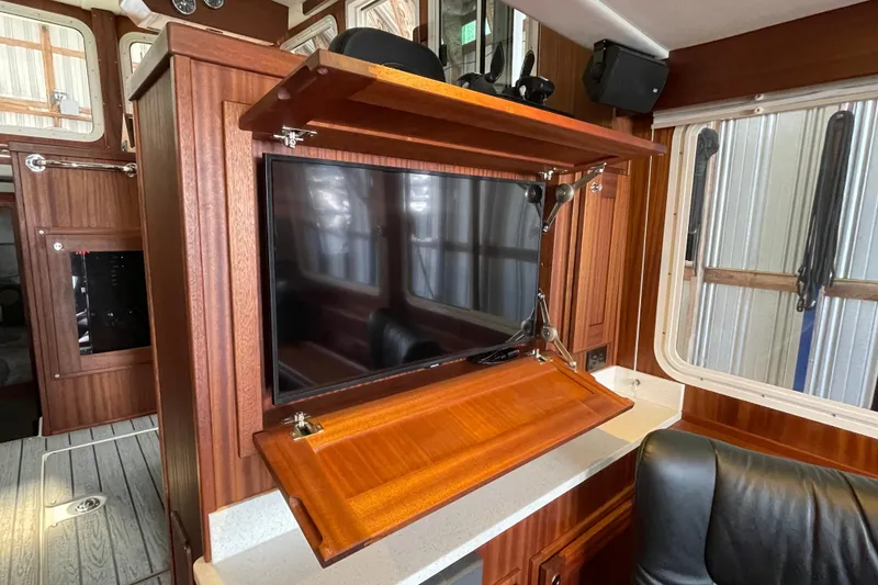 Slide: The Image of 2021 American Tug 362 interior with a foldable TV cabinet and wooden finish. - 18