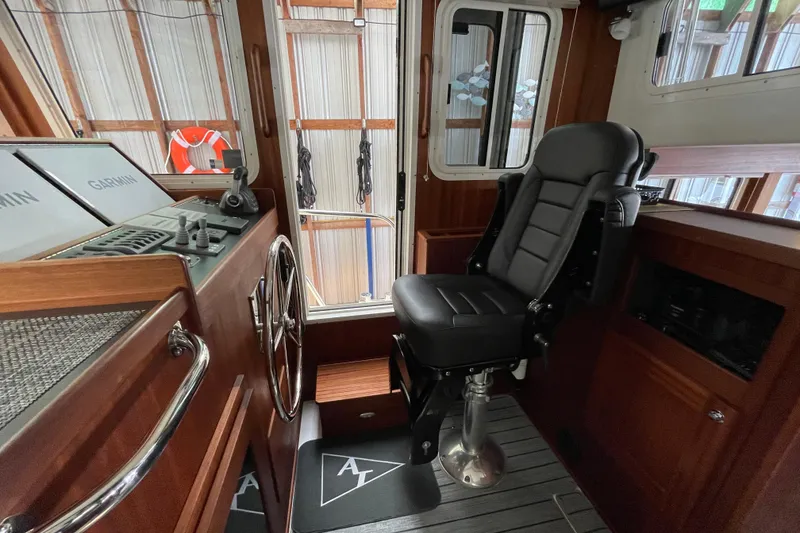 Slide: The Image of 2021 American Tug 362 helm with black captain's chair and navigation equipment. - 21