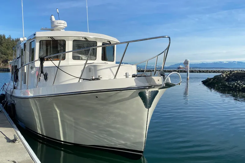 Slide: The Image of 2021 American Tug 362 docked in a serene marina setting. - 3